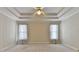 A spacious, carpeted bedroom with a tray ceiling, a ceiling fan, and two windows at 1301 Dayspring Trce, Lawrenceville, GA 30045