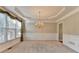 Formal dining room features a tray ceiling, chandelier, and large window with decorative drapes at 1301 Dayspring Trce, Lawrenceville, GA 30045