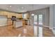 Eat-in kitchen boasts stainless appliances, light wood cabinets, and an island; view to deck at 1301 Dayspring Trce, Lawrenceville, GA 30045