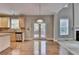 Stainless steel dishwasher in bright kitchen with granite countertops, light wood cabinets, and island seating at 1301 Dayspring Trce, Lawrenceville, GA 30045