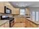 A view of a kitchen with stainless appliances, wood cabinets, granite counters, and wooden floors at 1301 Dayspring Trce, Lawrenceville, GA 30045