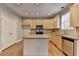 Efficient kitchen with light wood cabinets, island, and stainless steel appliances, offering ample storage at 1301 Dayspring Trce, Lawrenceville, GA 30045
