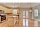An open kitchen with stainless steel appliances, wood cabinets, island, and wooden floors at 1301 Dayspring Trce, Lawrenceville, GA 30045