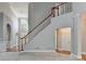Bright living room featuring staircase with hardwood, wainscotting, and view to the front door at 1301 Dayspring Trce, Lawrenceville, GA 30045