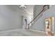 Spacious, carpeted living room with high ceilings and a staircase, offering an open and airy feel at 1301 Dayspring Trce, Lawrenceville, GA 30045