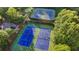Aerial view of four well-maintained blue and green tennis courts surrounded by trees at 1301 Dayspring Trce, Lawrenceville, GA 30045