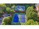 Aerial view of four well-maintained blue and green tennis courts surrounded by trees at 1301 Dayspring Trce, Lawrenceville, GA 30045