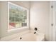 Bright bathroom featuring a soaking tub with chrome fixtures and a view to the backyard deck at 215 Nina Circle Cir, Locust Grove, GA 30248