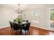 Bright dining room featuring a modern chandelier, dark wood table set, and access to an outdoor deck at 215 Nina Circle Cir, Locust Grove, GA 30248