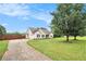 Charming home featuring a well-manicured lawn and long driveway leading to an attached garage at 215 Nina Circle Cir, Locust Grove, GA 30248