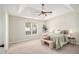 Well-lit main bedroom features tray ceilings, a ceiling fan, and soft, neutral tones at 215 Nina Circle Cir, Locust Grove, GA 30248