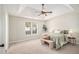 Bright main bedroom with a trey ceiling, soft carpet, neutral walls, and a view to the landscaped yard at 215 Nina Circle Cir, Locust Grove, GA 30248