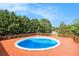 Backyard above-ground pool surrounded by a wooden deck and lush greenery at 215 Nina Circle Cir, Locust Grove, GA 30248