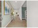 Inviting hallway with hardwood floors, neutral paint, and stylish decor, seamlessly connecting living spaces at 216 Paisley Way, Locust Grove, GA 30248