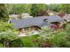 Beautiful aerial view of a brick home with screened porch and outdoor patio surrounded by colorful flowers at 3755 Kayanne Ct, Tucker, GA 30084