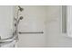 This is a close up shot of a bathroom with a dual shower and a hand rail. The tiles are white and the bathroom is clean at 3755 Kayanne Ct, Tucker, GA 30084
