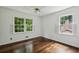 Bedroom featuring hardwood floors, a ceiling fan, and two windows which face the foliage outside at 3755 Kayanne Ct, Tucker, GA 30084