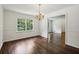 Formal dining room with hardwood floors, chandelier, and large windows providing ample natural light for meals at 3755 Kayanne Ct, Tucker, GA 30084