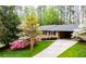 Brick home with an attached carport, well-manicured lawn, and landscaping with vibrant flowering trees at 3755 Kayanne Ct, Tucker, GA 30084