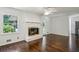 Inviting living room with a painted brick fireplace, hardwood floors, and large window to outdoor at 3755 Kayanne Ct, Tucker, GA 30084