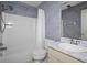 Cozy bathroom featuring a shower-tub combo, patterned wallpaper, and vanity sink at 140 Carriage Cir, Stockbridge, GA 30281
