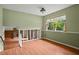 Sunlit living room with wood flooring, neutral walls, and a large window overlooking the yard at 140 Carriage Cir, Stockbridge, GA 30281