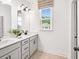 Bathroom featuring double vanity, white cabinets, large window and modern fixtures at 330 Meacham Ct, Dacula, GA 30019