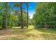 Large backyard surrounded by trees, with a green lawn at 3620 Beaver Cove Rd, Cumming, GA 30041