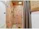 Bathroom shower stall with brown tiles and shower head. The walls are a combination of white and wooden panels at 3620 Beaver Cove Rd, Cumming, GA 30041