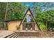 A-frame home featuring a wooden deck with seating and large glass windows surrounded by a lush, green landscape at 3620 Beaver Cove Rd, Cumming, GA 30041