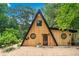Charming A-frame home showcasing wood siding, black trim, and unique round windows at 3620 Beaver Cove Rd, Cumming, GA 30041