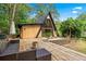 A-frame home with a large wooden deck with outdoor seating, lush landscaping and wooded scenery at 3620 Beaver Cove Rd, Cumming, GA 30041