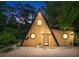 A-frame home featuring natural wood siding, black trim, unique round windows and stylish front door at 3620 Beaver Cove Rd, Cumming, GA 30041