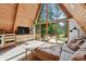 The living room has a wooden A-frame ceiling with a large, triangle window and sliding doors to the deck at 3620 Beaver Cove Rd, Cumming, GA 30041