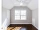 Cozy bedroom with sloped ceiling, hardwood floors, and a large window at 469 Mellview Sw Ave, Atlanta, GA 30310