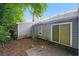 Backyard featuring gray siding, lush greenery, and a sliding door entry, offering a private outdoor space at 5354 Cherry Wood Drive Dr, Stone Mountain, GA 30083