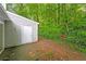 Backyard showcasing a door and gray siding, surrounded by mature trees and natural landscaping at 5354 Cherry Wood Drive Dr, Stone Mountain, GA 30083