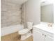 Modern bathroom featuring tiled walls, bathtub, and a sleek vanity with ample storage space at 5354 Cherry Wood Drive Dr, Stone Mountain, GA 30083