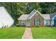 Charming brick home with a manicured lawn and inviting front entrance surrounded by mature trees at 5354 Cherry Wood Drive Dr, Stone Mountain, GA 30083