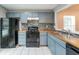 Functional kitchen featuring painted cabinets, updated appliances, and a mosaic tile backsplash at 5354 Cherry Wood Drive Dr, Stone Mountain, GA 30083