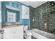 Bathroom with modern vanity, toilet, tub, and tile shower with beautiful blue accent wall at 2111 Bellrick Nw Rd, Atlanta, GA 30318