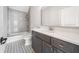 Charming bathroom features gray cabinets, white counter, and decorative patterned tile floor with tub and shower at 2111 Bellrick Nw Rd, Atlanta, GA 30318