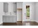 Modern kitchenette features gray cabinets, subway tile backsplash, and stainless steel sink with views to an exterior door at 2111 Bellrick Nw Rd, Atlanta, GA 30318