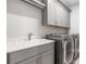 Laundry room with gray cabinets, a sink, and front-load washer and dryer at 2111 Bellrick Nw Rd, Atlanta, GA 30318