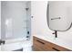 Modern bathroom features a wooden vanity, oval mirror, white backsplash, and a shower with glass shelving at 2808 Hosea L Williams Dr, Atlanta, GA 30317