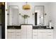 Bathroom featuring double sinks, two mirrors, modern lighting, and white cabinetry at 2808 Hosea L Williams Dr, Atlanta, GA 30317
