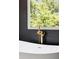 Modern bathtub with gold faucet and black, textured tile at 2808 Hosea L Williams Dr, Atlanta, GA 30317