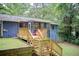 Backyard view of a blue house with a deck, set in a lush green wooded area at 3076 Montheath Pass, Duluth, GA 30096
