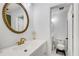 Bright bathroom featuring a white vanity, gold fixtures, and an oval mirror at 3076 Montheath Pass, Duluth, GA 30096