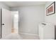 Minimalist bedroom featuring gray walls, carpet flooring, and an open doorway to the ensuite bathroom at 3076 Montheath Pass, Duluth, GA 30096